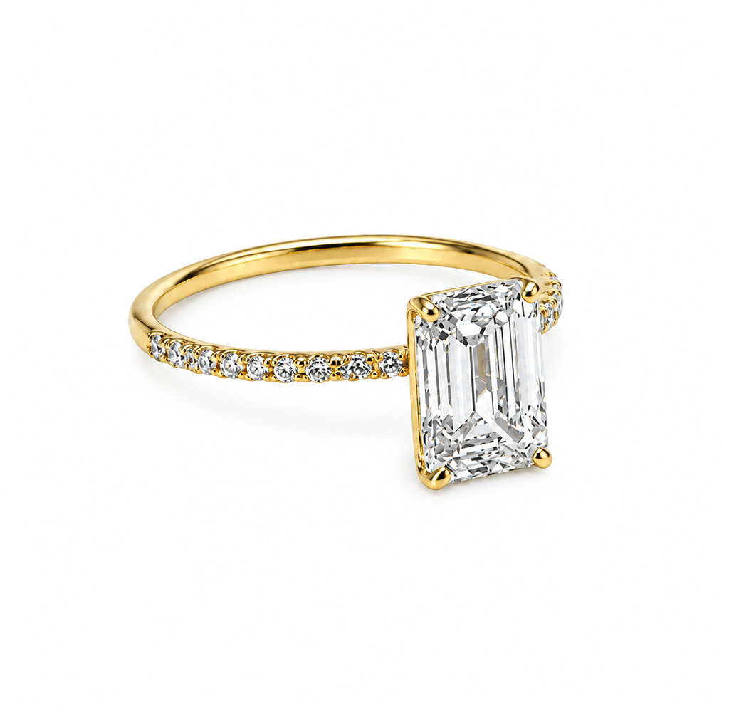 Sideprofil af KLAR diamantring i 14 karat gulguld med firekløers fatning og stor emerald-cut diamant.